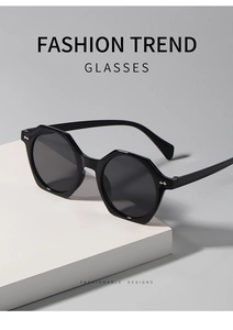 Detail shot of black hexagonal sunglasses with silver butterfly rivets on the frame