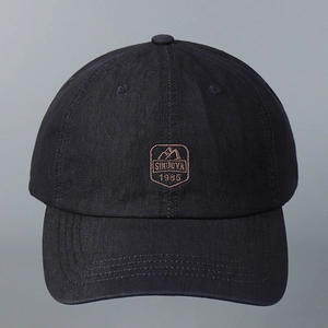 Detailed view of mountain embroidery and logo on black cotton baseball cap