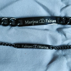 Detail of personalized black stainless steel couple bracelets with custom laser engraving