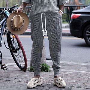 Detail of grey men's joggers showing drawstring waist and cable knit texture