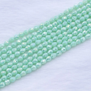 Macro detail of faceted mint green strawberry drop beads for DIY jewelry making