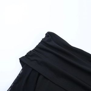 Detail of black knit and sheer mesh fabric with intricate pleated lace texture