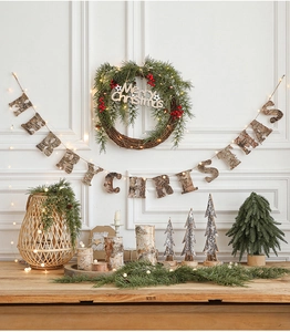 Detail of wooden Merry Christmas banner with pine wreath and warm fairy lights decor