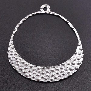 Macro detail of the hammered texture on this silver stainless steel crescent pendant