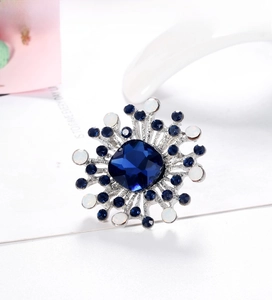 Macro view of blue gemstone brooch with snowflake shape and silver alloy base