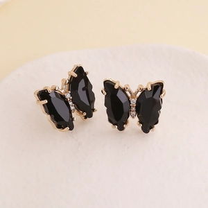 Close-up of black butterfly earrings with gold frame and white crystal details