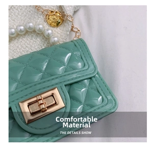 Detail of mint green quilted jelly bag with pearl handle and gold twist lock