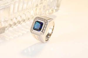 Macro detail of men's silver ring featuring a square blue sapphire and pave zircon accents