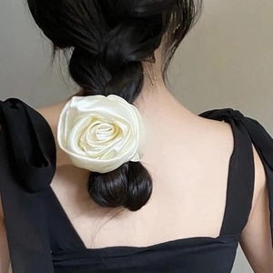 Detail of cream white silk rose scrunchie with layered petals on a low ponytail hair
