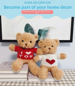Detail of brown teddy bears in red and white knitted sweaters on a stack of books