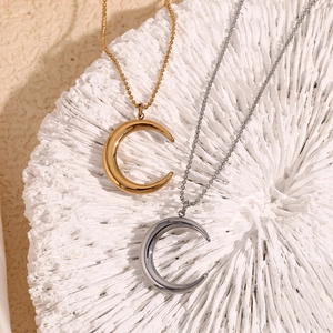 Detailed view of crescent moon pendants in gold and silver on bead chain necklaces