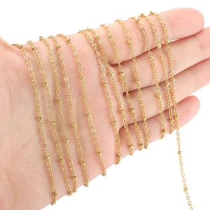Golden stainless steel satellite chain necklace held in hand to show fine detail and texture