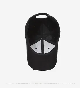 Detailed inner view of black cotton baseball cap showing white lining and ventilation holes