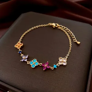 Bracciale placcato oro 18K con quadrifogli in zirconia colorata su sfondo di seta
