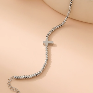 Close-up of silver beaded bracelet with cross pendant and adjustable extension chain
