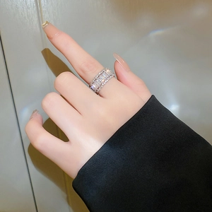 Detailed view of multilayer zircon ring featuring baguette and round cut stones on hand