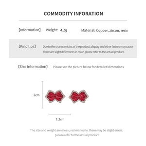 Detail showing red bow clip earrings with zircon inlay and dimensions of 2cm by 1.3cm