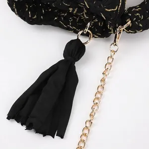 Handmade crochet crossbody bag in black and gold yarn with tassel and chain strap