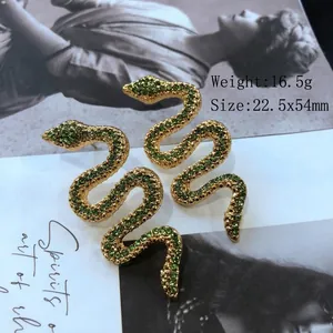 Vue détaillée des boucles d'oreilles serpent en or avec strass verts et dimensions 22,5*54mm