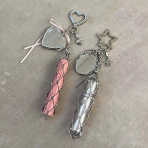 Detail of metal mesh lipstick holder keychain with small mirror and pink ribbon decor