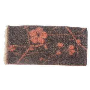 Close-up of wool texture and floral jacquard pattern on a dark taupe scarf with tassels