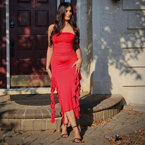 Detail of red tube top dress featuring elegant side ruffle trim and slim fit cut