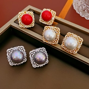 Macro view of vintage square zircon earrings with red, white, and gray pearls detail