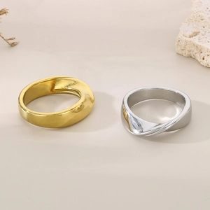 Detail of twisted irregular stainless steel rings in polished gold and silver finishes