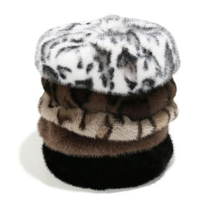 Five assorted faux mink leopard and solid color beret hats stacked on white background