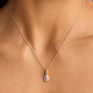 Primo piano di una collana d'argento con pendente a goccia e pietra preziosa rosa