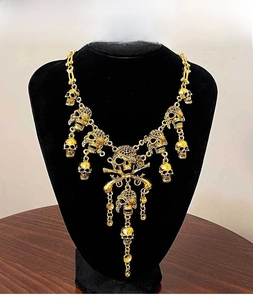 Detailed close-up of gothic skull necklace with antique gold plating and tassels