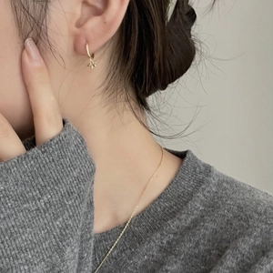 Minimalist 925 sterling silver hoop earrings with leaf charms shown on a model