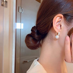 Elegant gold pearl drop earrings with micro-inlaid zircon worn by a female model
