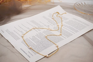 Detail of layered freshwater pearl necklace on a vintage card with brown tulle background