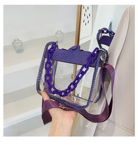 Detail of purple transparent PVC handbag featuring rhinestone trim and chunky chain strap