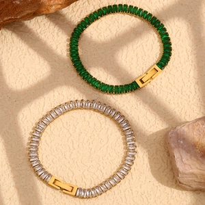Macro shot of 18K gold plated bracelets with green and clear rectangular zircon stones