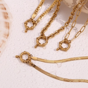 Detail of four gold-plated stainless steel necklaces with large round spring clasps