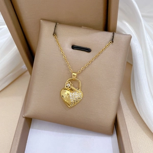Close-up of gold heart lock necklace with Love You engraving and sparkling crystals