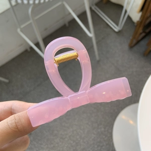 Handheld pink translucent resin butterfly hair claw clip with golden metal spring