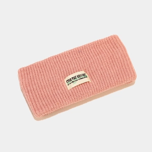 Close-up of pink knitted sports headband featuring ribbed texture and white logo patch