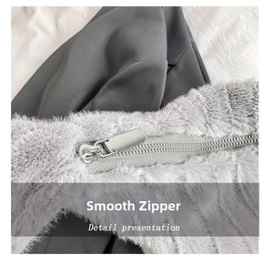 Detail shot of the smooth silver metal zipper on a grey plush faux fur tote bag