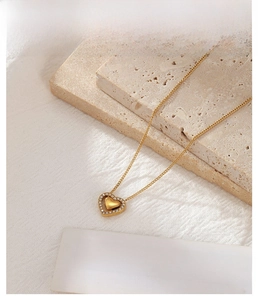 Detailed macro view of a gold heart pendant necklace with shimmering zircon stones