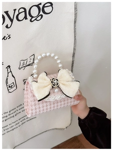 Pink houndstooth mini bag featuring pearl handle and beige bow with camellia charm