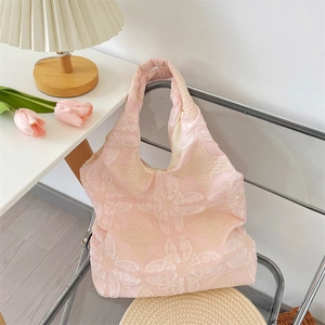 Close-up of pink tote bag featuring delicate white butterfly embroidery and soft texture