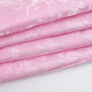 Close-up of pink floral jacquard fabric with elegant satin texture and relief patterns