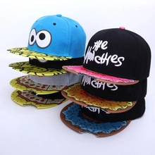 Group display of colorful children's baseball caps with cartoon pizza and donut prints