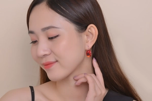Close-up of elegant oval red gemstone earrings worn by model for fashion display
