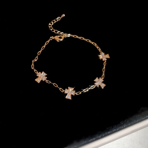 Detailansicht der goldenen Kreuzanhänger mit funkelndem Zirkonia an einem Gliederkettenarmband