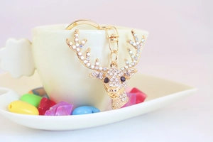 Close-up of a sparkling reindeer keychain with crystal rhinestones in a white cup