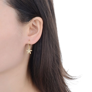 Elegant gold starfish drop earrings with cubic zirconia crystals worn by a model